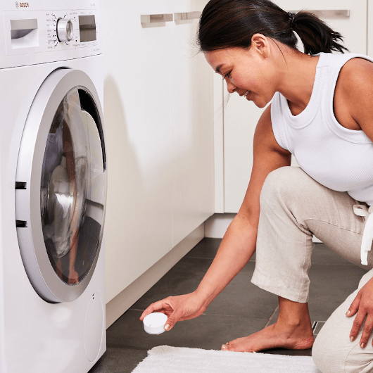 woman placing sensor near washing machine